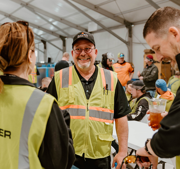 Sauer Group team member smiling at a busy event with colleagues.