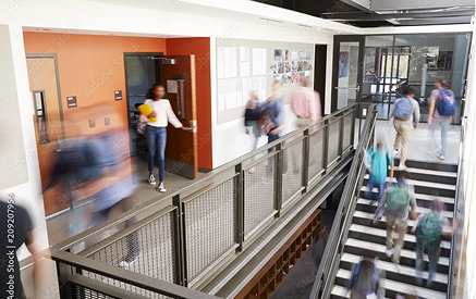 Busy office corridor with people walking and working at Sauer Group.
