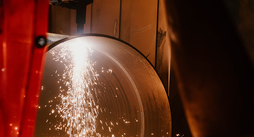 Welding process with sparks at Sauer Group manufacturing facility.