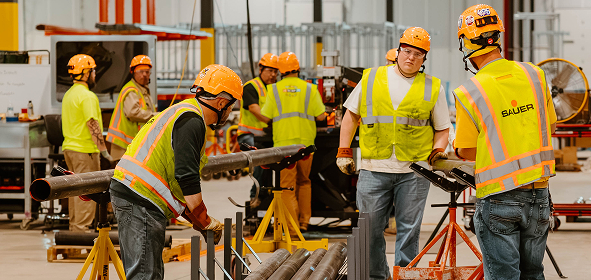 Construction workers at Sauer Group collaborating on industrial project.